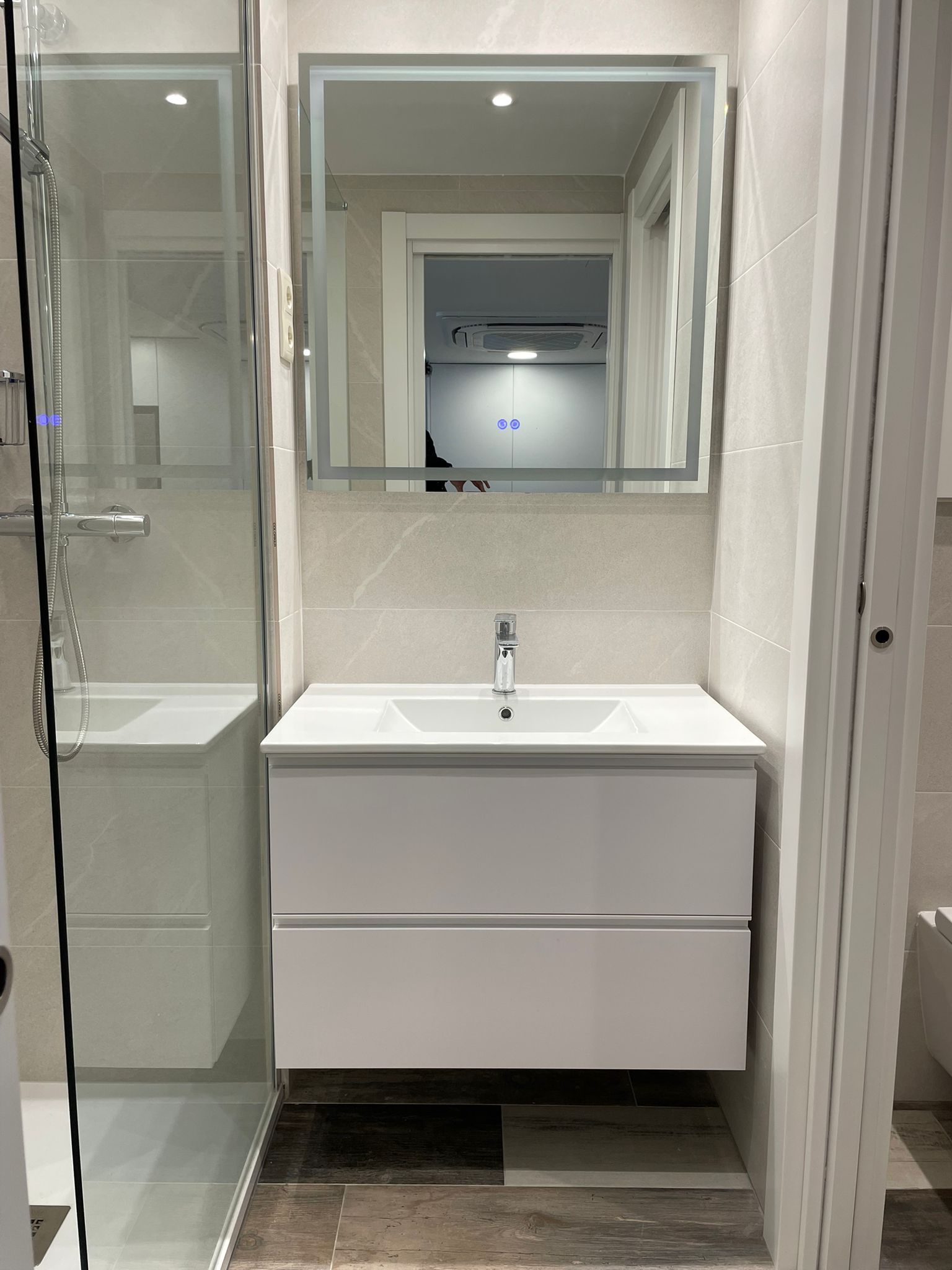 Reforma de bany amb lavabo flotant i dutxa de vidre